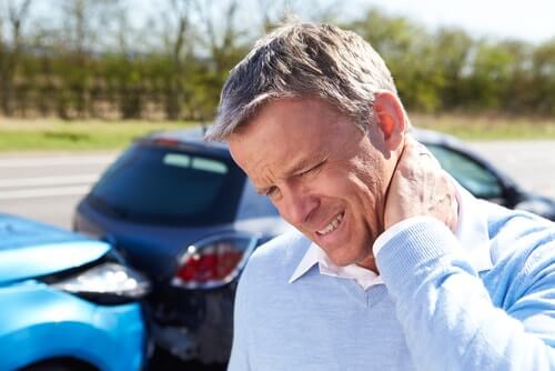 Man grabbing his neck after a car accident